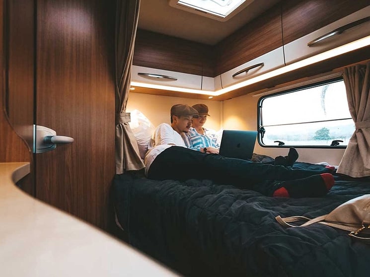 Couple watching a movie in the motorhome bed