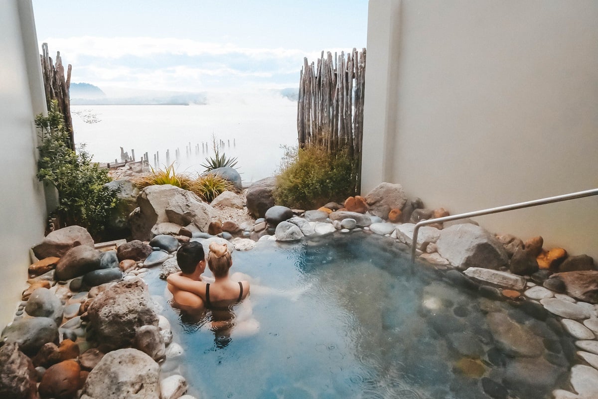 Couple enjoying the view from a natural hot pool in Rotorua, New Zealand