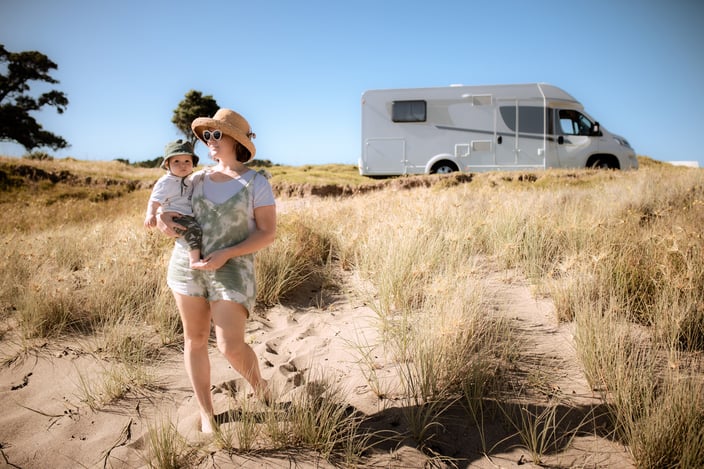 baby and mum walking to beach with motorhome