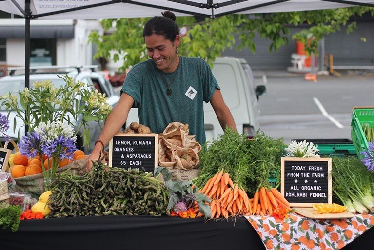 man behind a New Zealand farmers' market stall