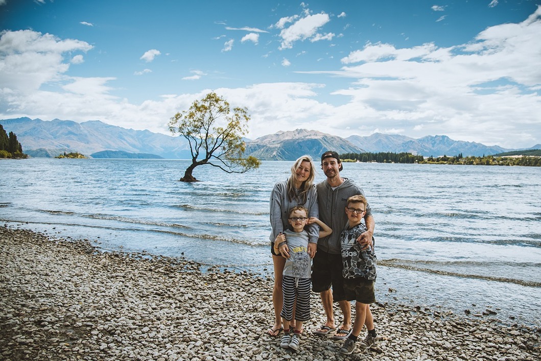 Family posing in front of That Wanaka Tree