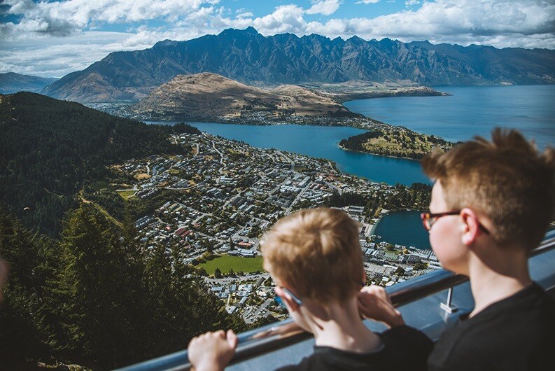 Two kids looking over Queenstown view from Queenstown Skyline