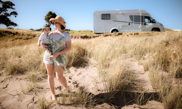 baby and mum walking to beach with motorhome