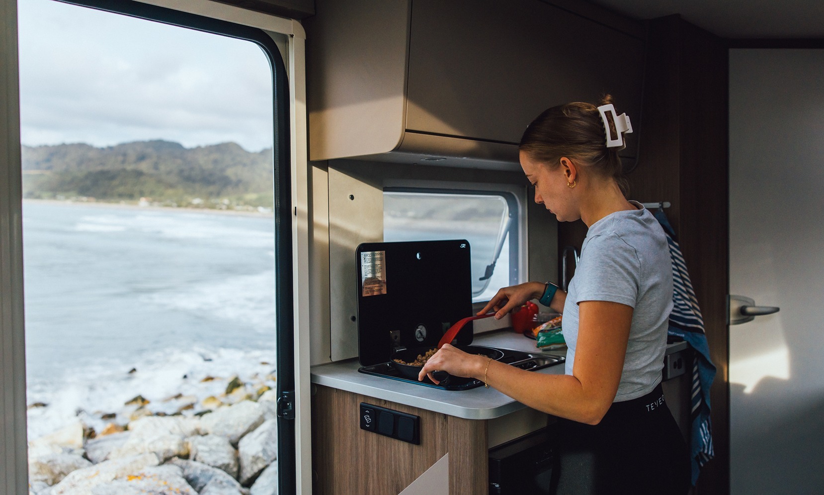 woman cooking in a Wilderness motorhome