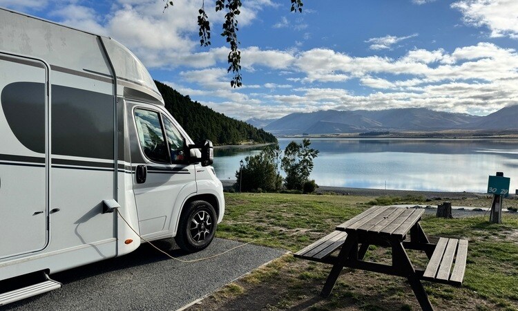 A Wilderness motorhome camping at a holiday park in New Zealand by the side of a lake