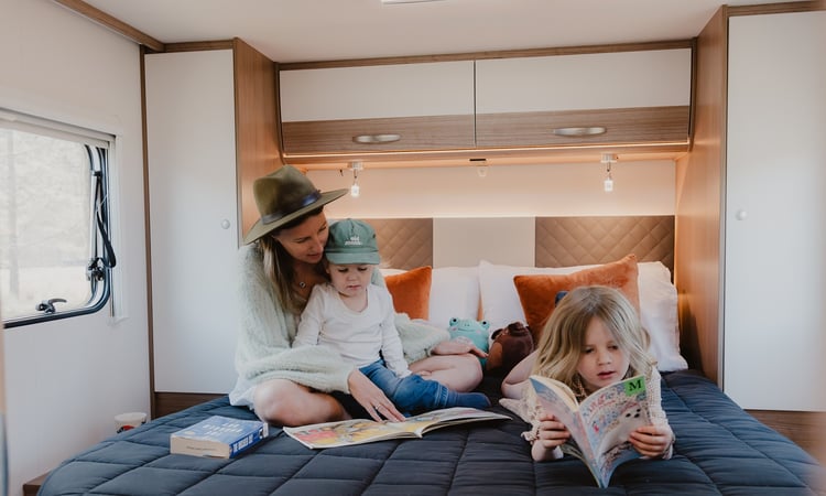 Interior-reading on bed with children