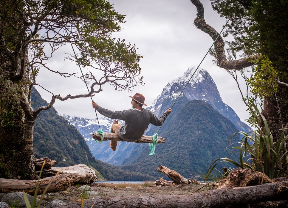 A traveller on a swing at Milford Sound