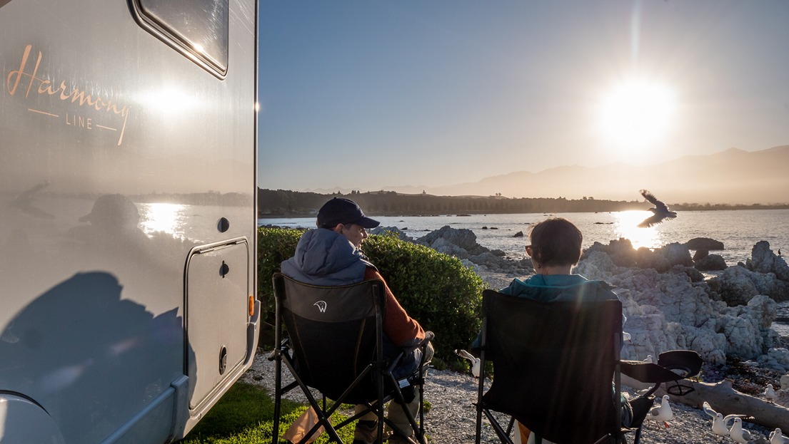 Senior couple enjoying sunset by their motorhome