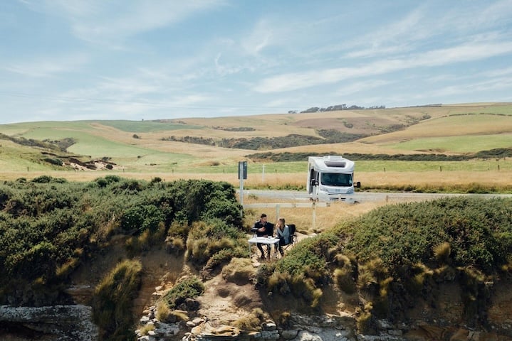 Couple clifftop eating in The Catlins