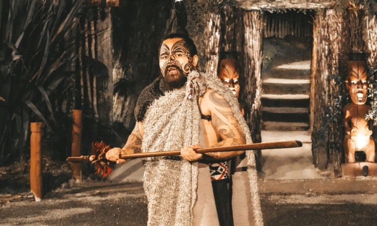 A Maori man doing a performance at a Maori village