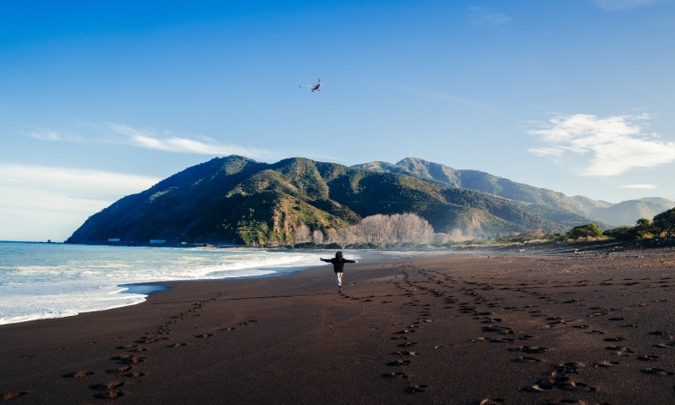 A man running around a beach in New Zealand
