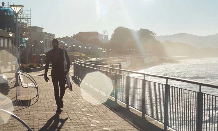 Surfer walking at St Clair beach