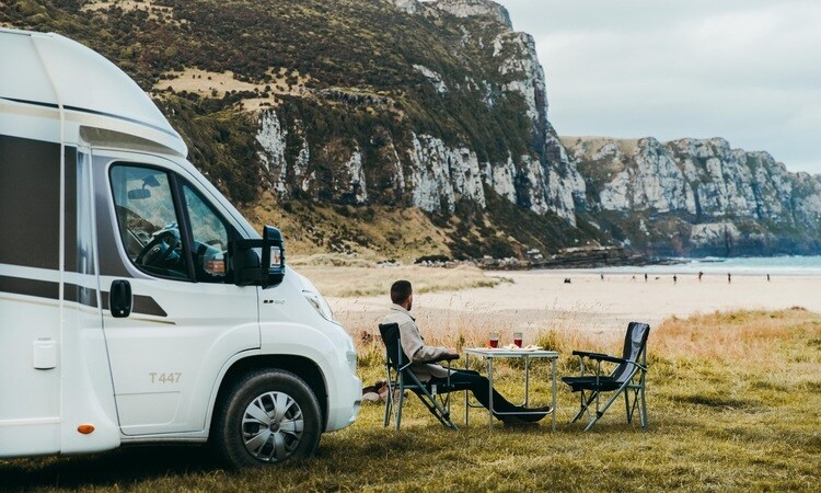 A man enjoying a peaceful morning outside of his Wilderness motorhome in Caitlin