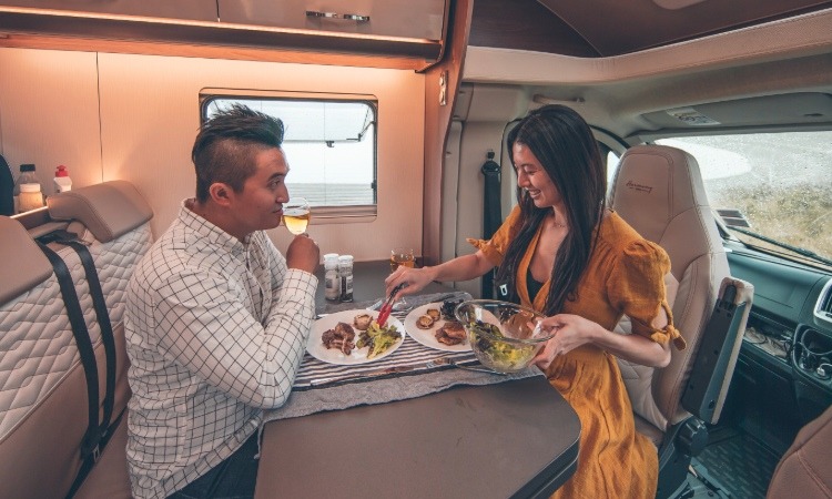 A couple enjoying a meal together in a Wilderness motorhome