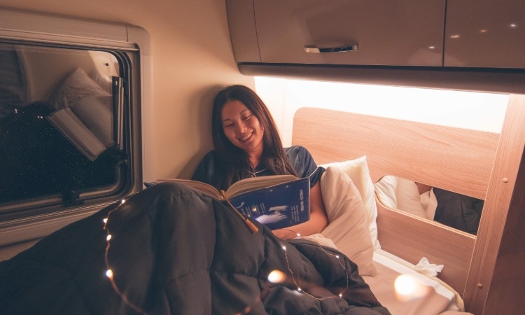 A woman reading a book while relaxing in a Wilderness motorhome