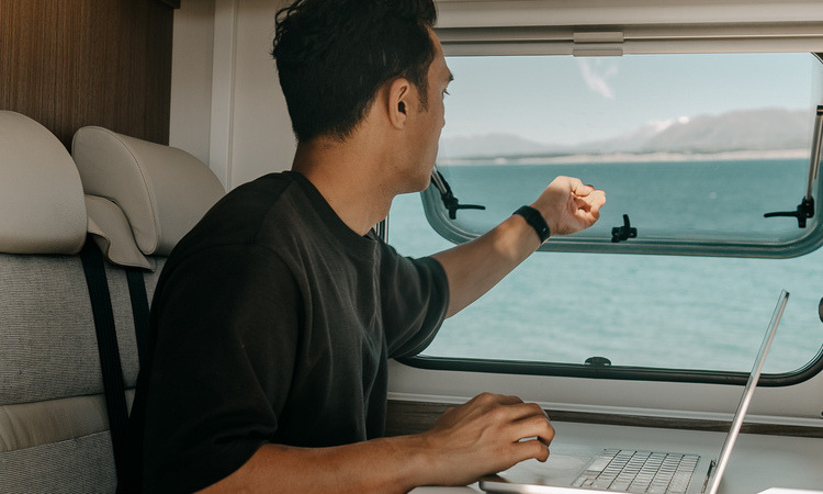 A digital nomad looking out a view while working remotely in a motorhome
