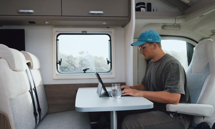 A digital nomad working remotely in a motorhome with a swivel seat