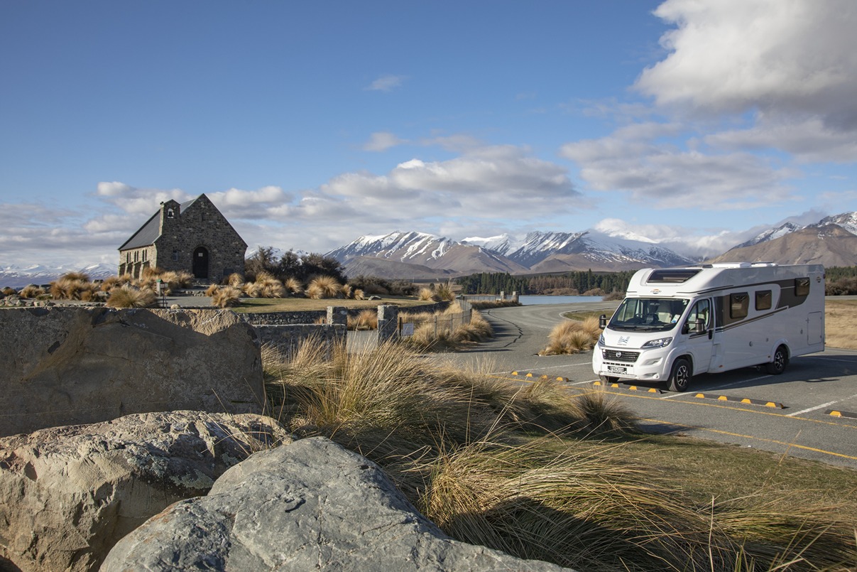 A motorhome parked up at a parking spot in Lake Tekapo