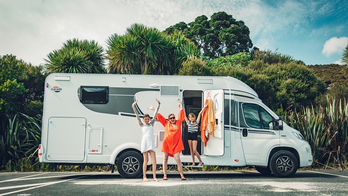 Happy family posing outside of a motorhome