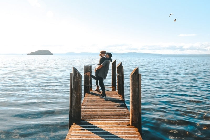 couple on a honeymoon kissing New Zealand lakeside