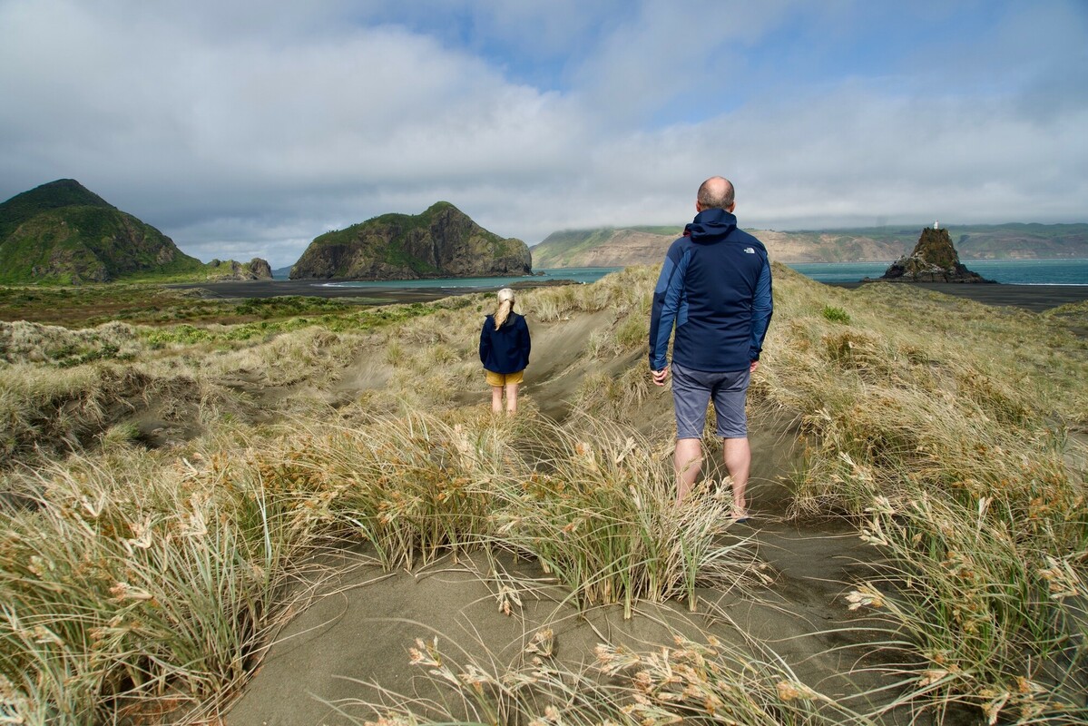 Northland harbour view with two people standing on sand dunes