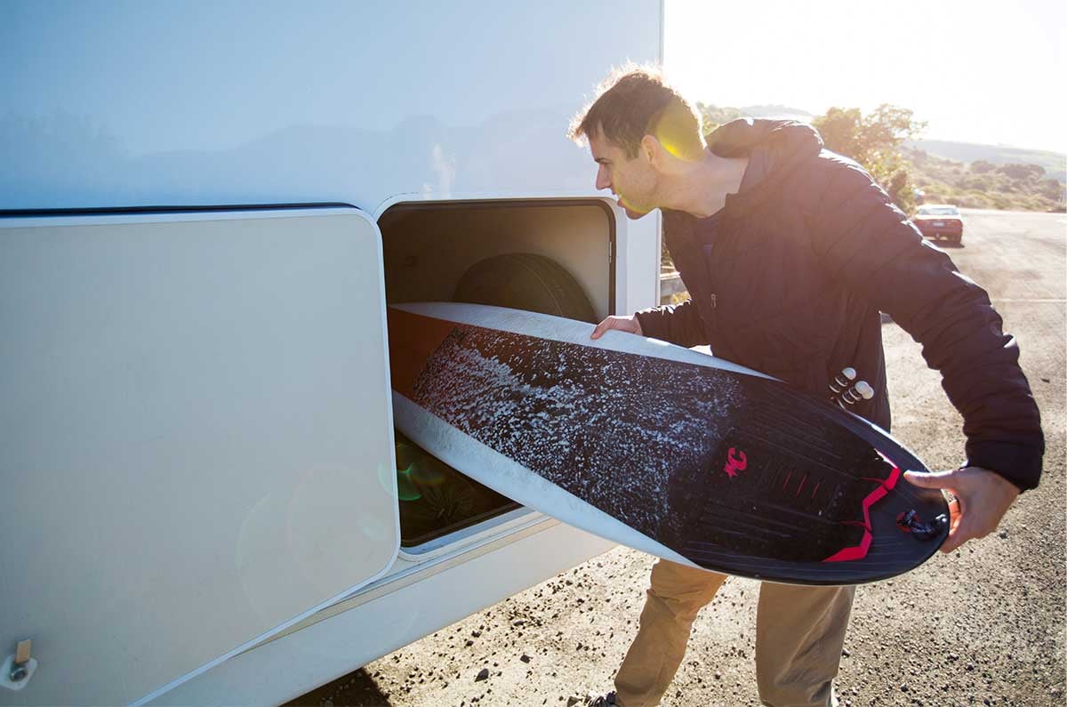 Loading surfboard into motorhome garage