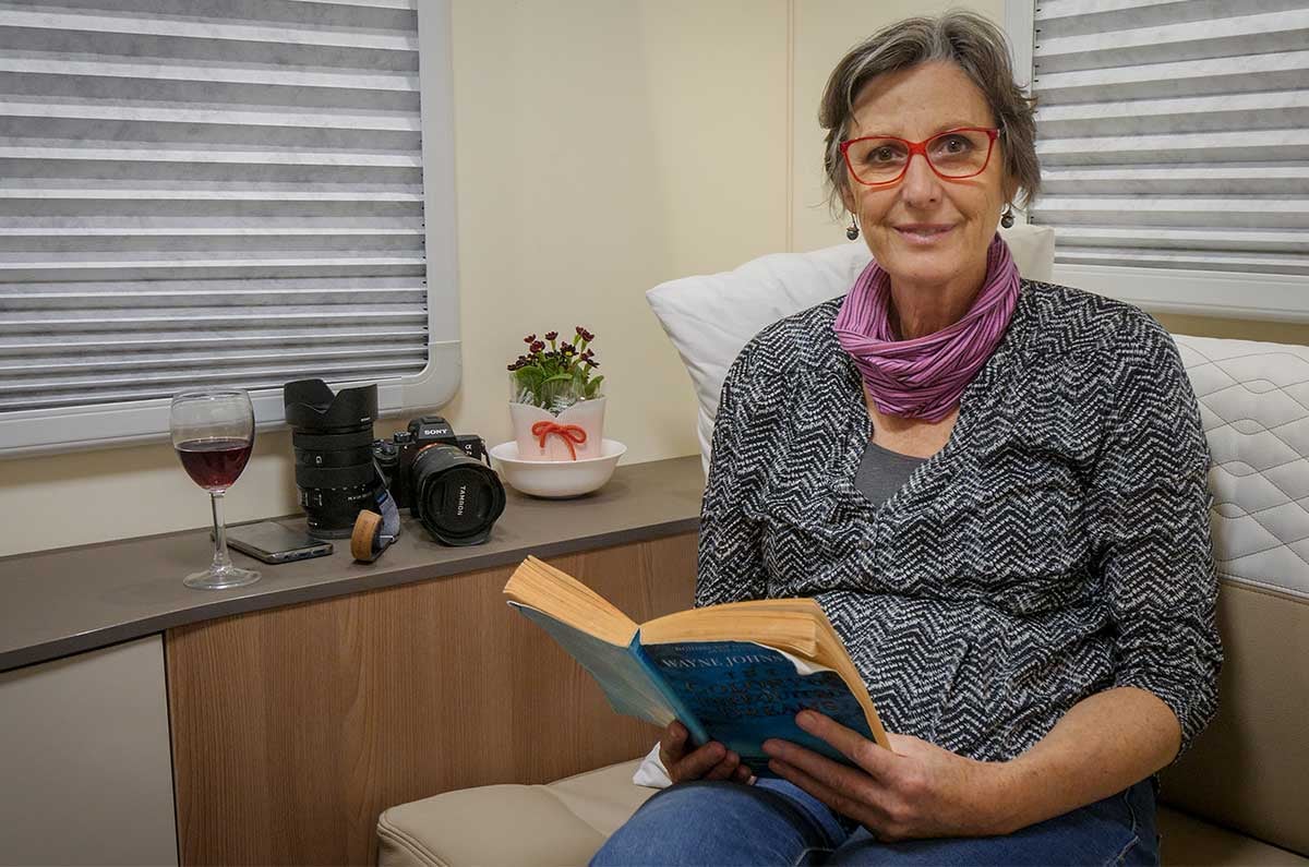 Kathy Hart reading-a-book-in-the-rear-lounge-of-the-Suite-Wilderness motorhome