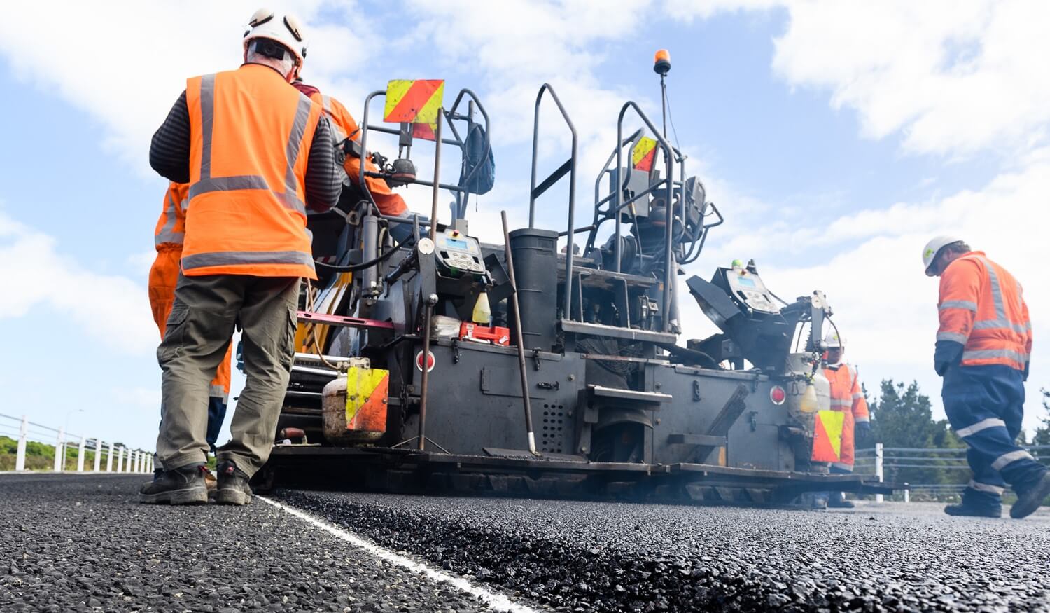 Road maintenance workers using machinery on road