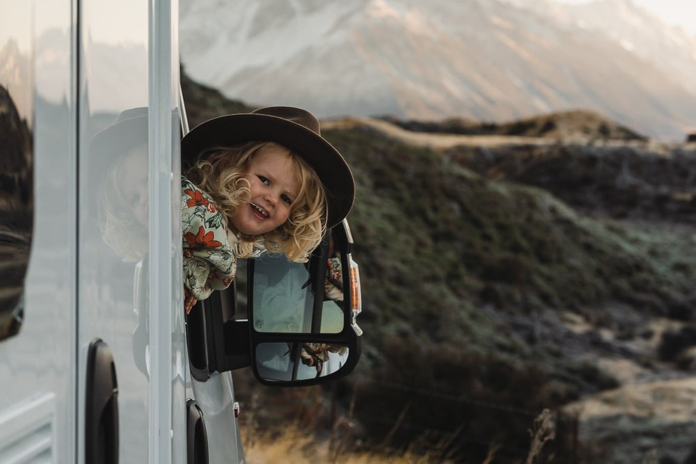 toddler leaning out motorhome window mountains child toddler compact plus wilderness motorhome new zealand