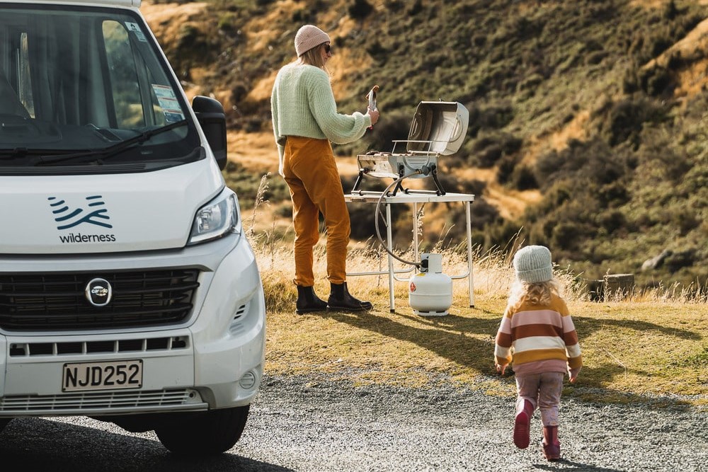 barbecue bbq child toddler running woman compact plus wilderness motorhome new zealand
