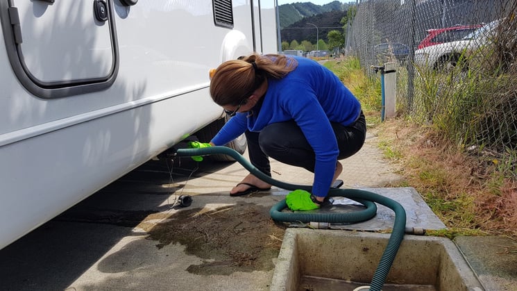 person emptying motorhome tanks at dump station