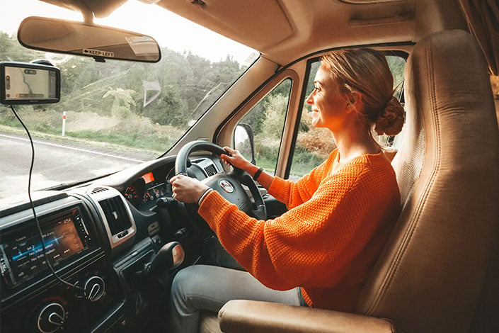 woman behind steering wheel driving a Wilderness motorhome