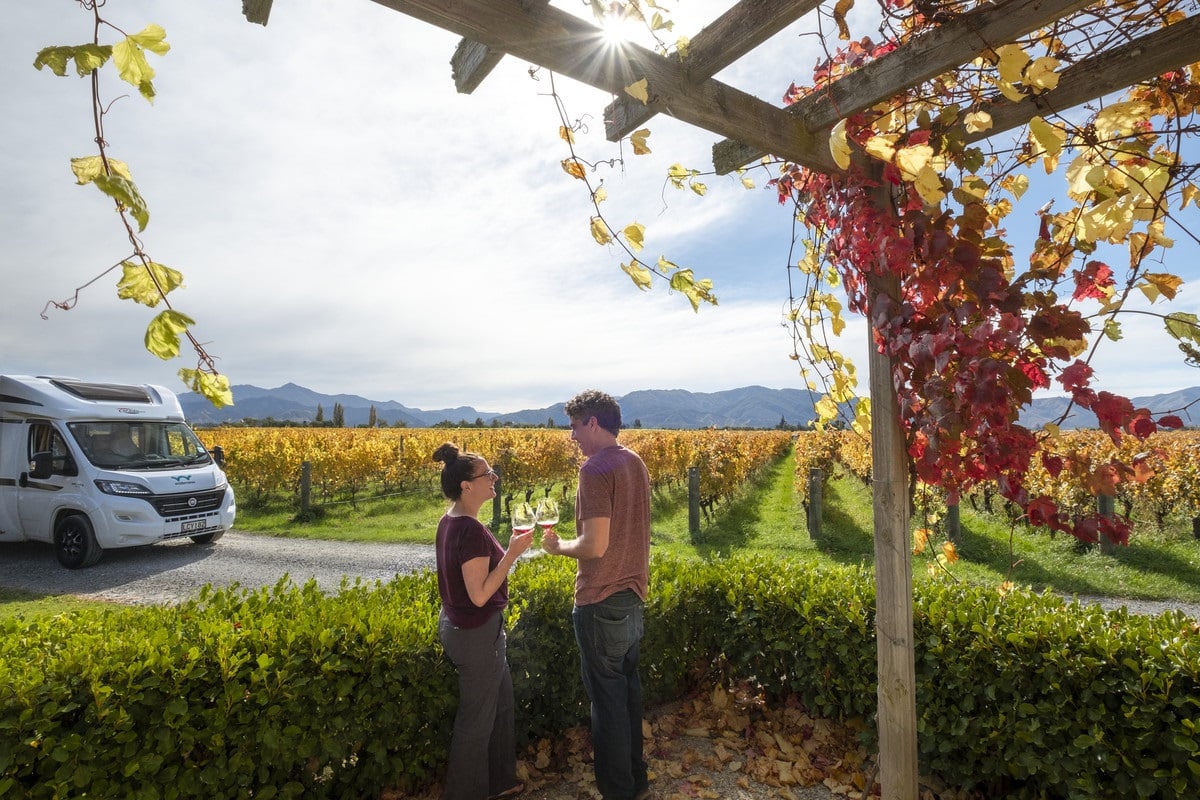 couple in a New Zealand winery and Wilderness motorhome background