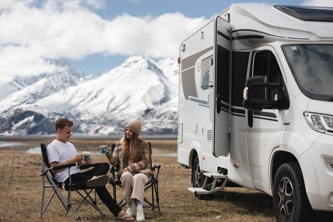 Couple relaxing outside of motorhome