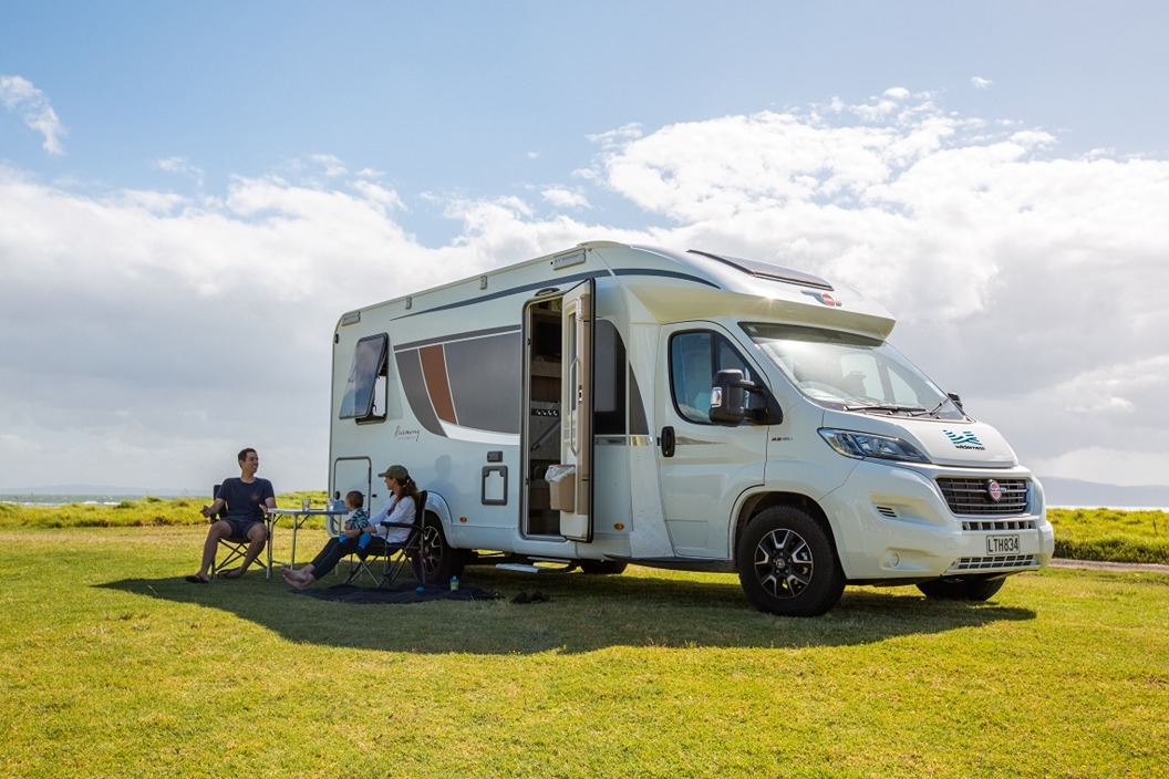 Family relaxing outside of motorhome